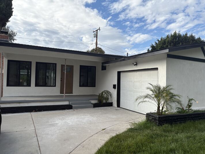 Remodeled white stucco exterior with black trim and attached garage at 2715 Petaluma, Long Beach